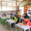 A group of children seated and working on school assignments as part of an academic support programme in Kiulu, Sabah.