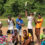 A group of boys outdoors holding badminton rackets, playfully posing with various cheerful expressions and dynamic stances against a sunny, natural backdrop.